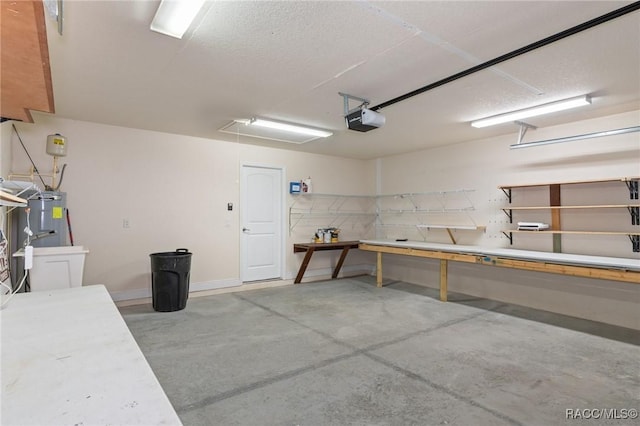 garage featuring a garage door opener, a workshop area, and electric water heater