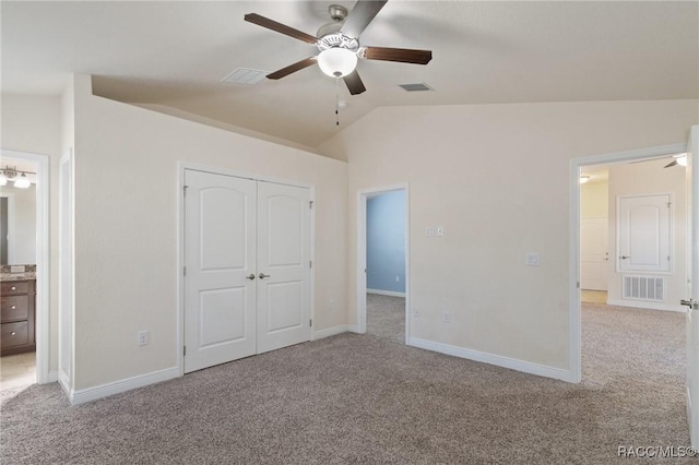 unfurnished bedroom with ceiling fan, a closet, lofted ceiling, and light carpet