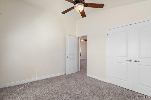 unfurnished bedroom featuring vaulted ceiling, carpet flooring, ceiling fan, and a closet