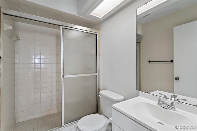 bathroom with vanity, toilet, and a shower with door