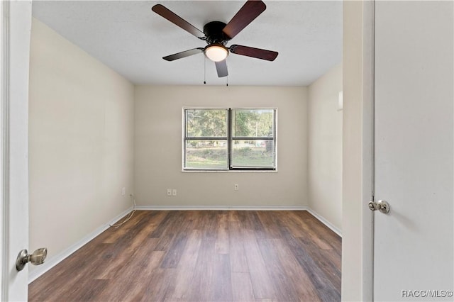 spare room featuring ceiling fan and dark wood-type flooring