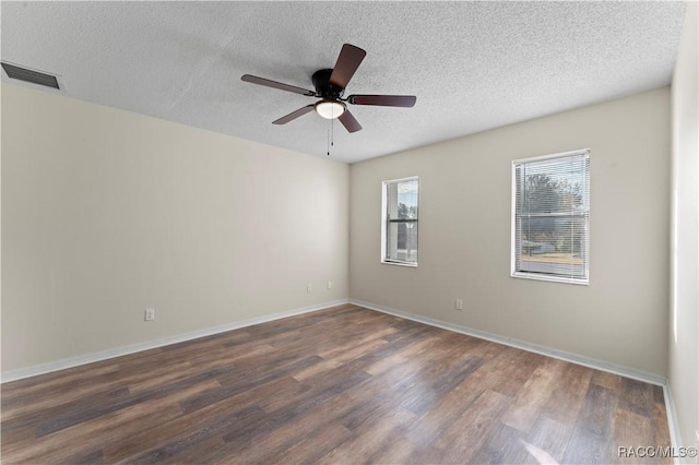 spare room with ceiling fan, dark hardwood / wood-style flooring, and a textured ceiling