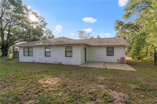 rear view of property with a lawn and a patio area