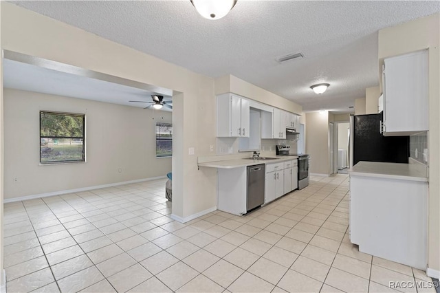 kitchen with decorative backsplash, white cabinets, light tile patterned flooring, and appliances with stainless steel finishes