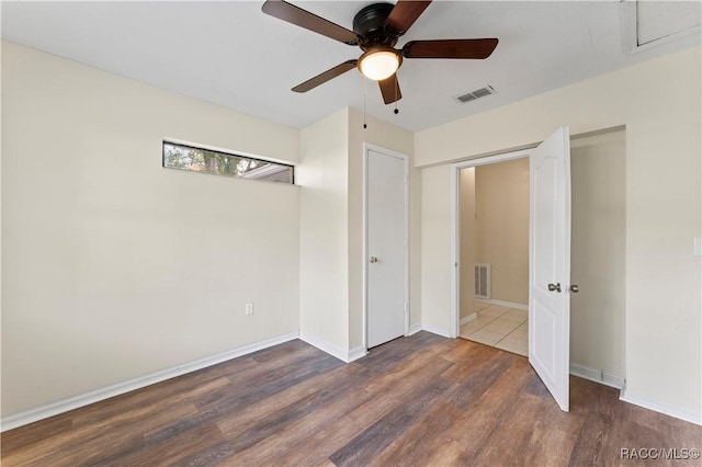 unfurnished bedroom featuring a closet, ceiling fan, and dark wood-type flooring