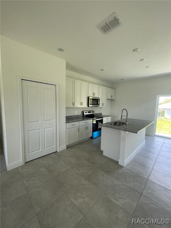 kitchen with sink, a kitchen island with sink, a breakfast bar, white cabinets, and appliances with stainless steel finishes