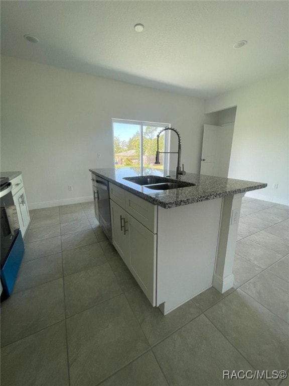 kitchen with white cabinets, stainless steel dishwasher, sink, and an island with sink