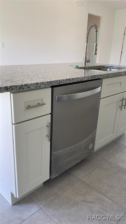 kitchen featuring dishwasher, white cabinets, light tile patterned flooring, and sink