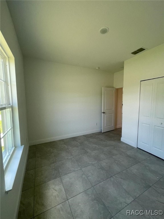 unfurnished bedroom featuring tile patterned flooring and a closet