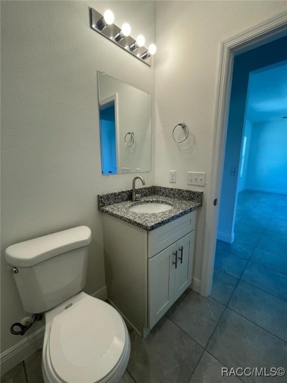 bathroom featuring tile patterned floors, vanity, and toilet