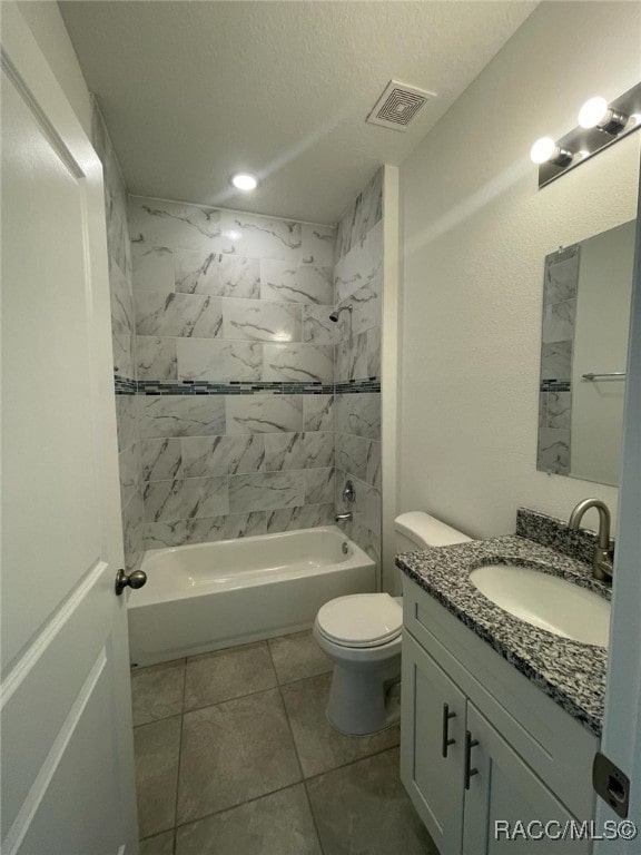 full bathroom featuring vanity, tiled shower / bath, tile patterned flooring, toilet, and a textured ceiling