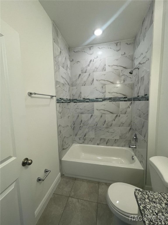 bathroom with tile patterned flooring, toilet, and tiled shower / bath