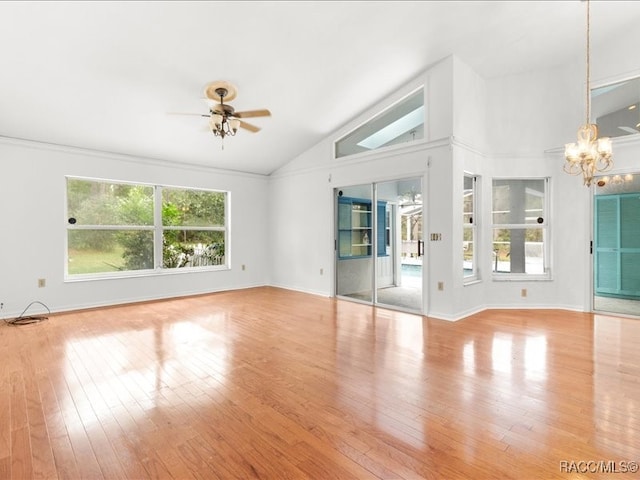 empty room with ceiling fan with notable chandelier, light wood-type flooring, and lofted ceiling