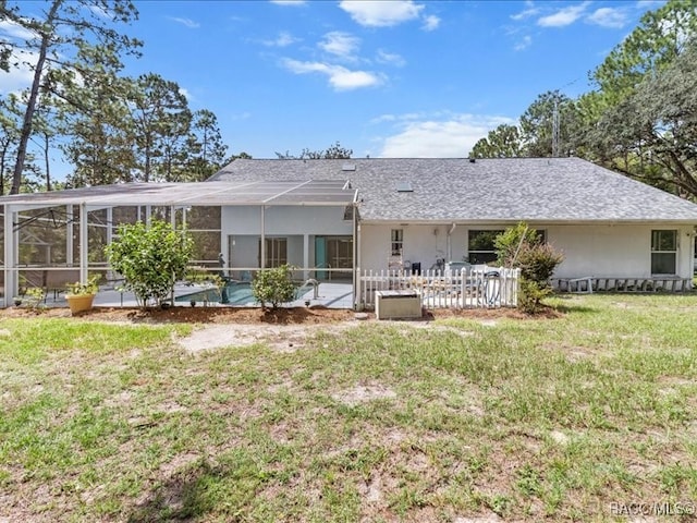 rear view of house featuring a yard and a lanai