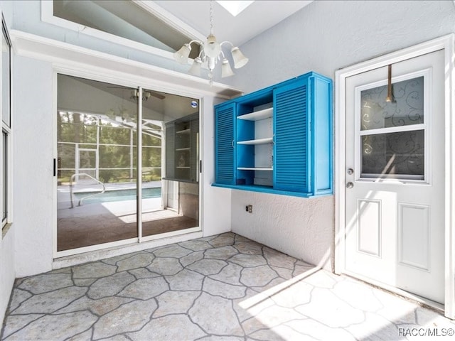 unfurnished sunroom with lofted ceiling and an inviting chandelier