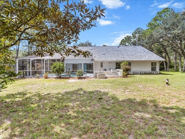 rear view of property featuring a yard and a lanai