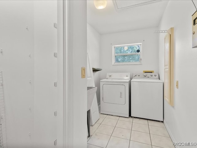 laundry area with light tile patterned floors and washing machine and clothes dryer