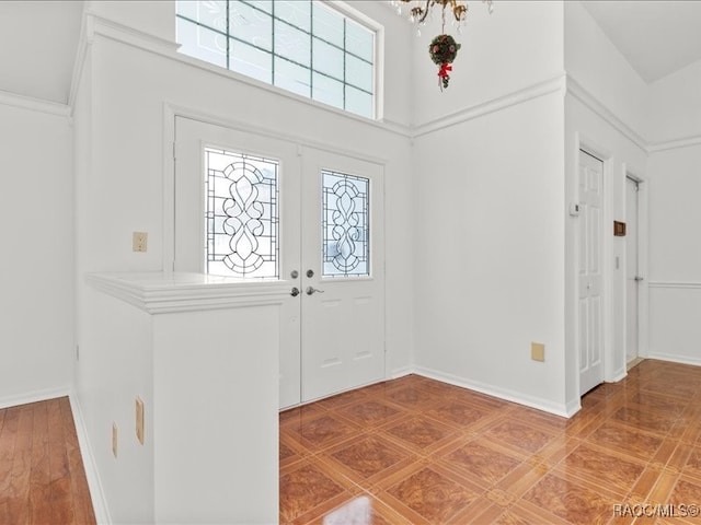 entrance foyer with tile patterned flooring, french doors, a towering ceiling, and plenty of natural light