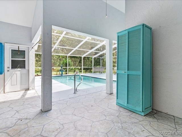 view of pool featuring glass enclosure and a patio