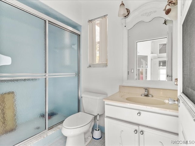 bathroom featuring vanity, toilet, an enclosed shower, and a wealth of natural light