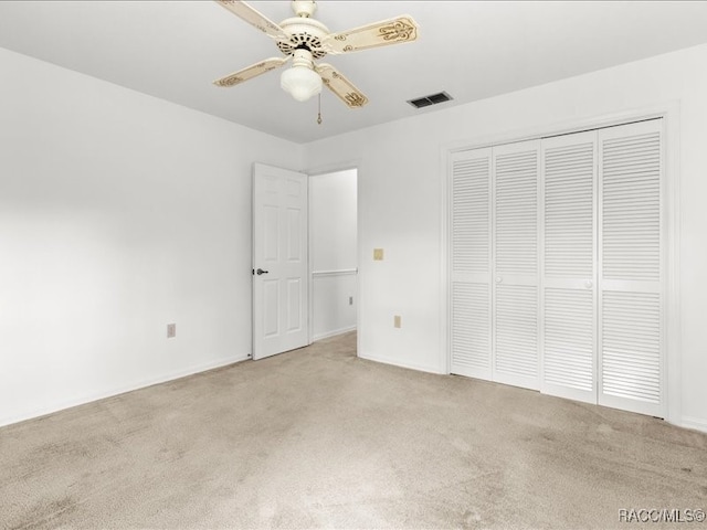 unfurnished bedroom with ceiling fan, a closet, and light carpet