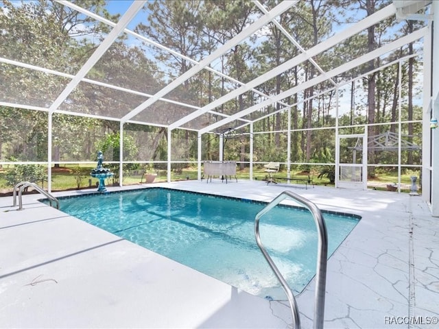 view of pool with glass enclosure and a patio area