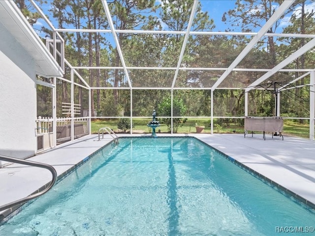 view of pool featuring glass enclosure and a patio area