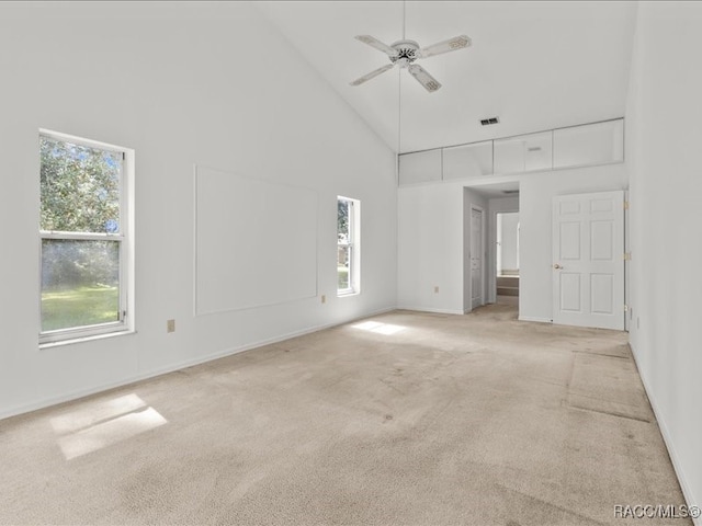 carpeted spare room with high vaulted ceiling and ceiling fan