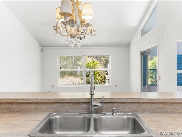 kitchen with a healthy amount of sunlight, lofted ceiling, sink, and a chandelier