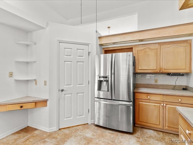 kitchen with stainless steel refrigerator with ice dispenser, backsplash, and light brown cabinets