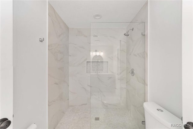 bathroom featuring toilet and tiled shower