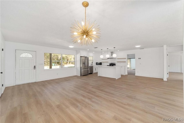 unfurnished living room with a textured ceiling, a chandelier, and light hardwood / wood-style floors