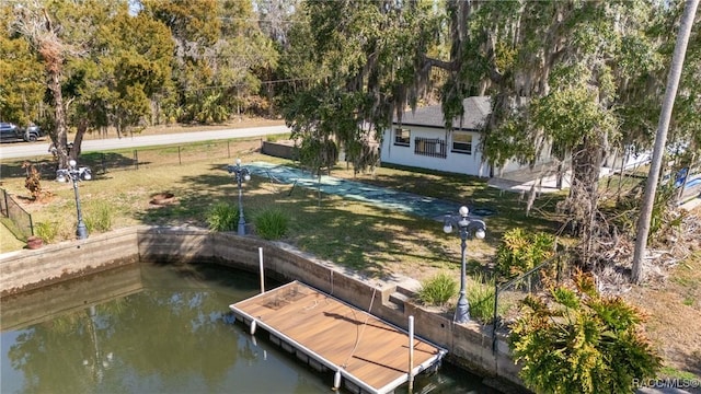 view of dock featuring a water view and a yard