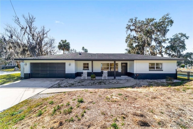 ranch-style home with a garage and covered porch