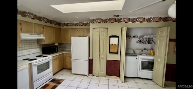 kitchen featuring light tile patterned floors, white appliances, tasteful backsplash, and washing machine and dryer