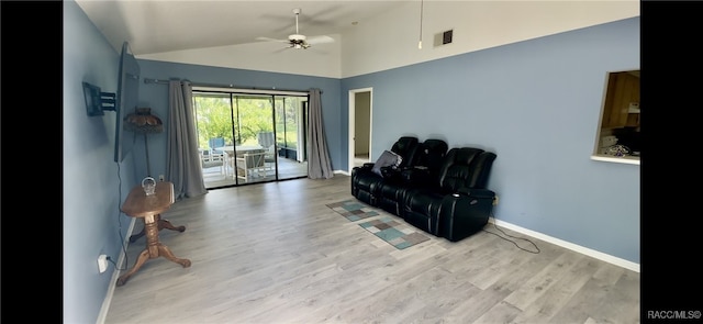 living area featuring light hardwood / wood-style floors, vaulted ceiling, and ceiling fan