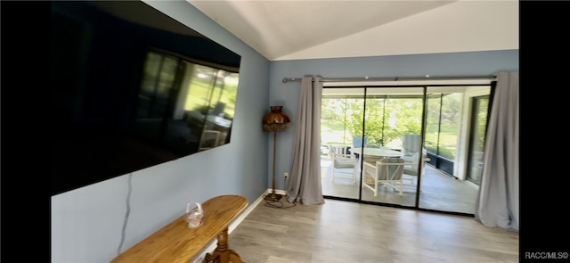 doorway featuring light hardwood / wood-style flooring and lofted ceiling