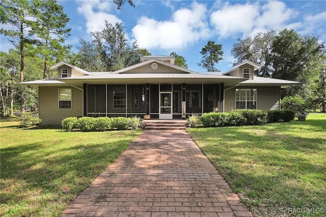 7802 N Fairwind Loop, Hernando, FL 34442 - view of front facade featuring a sunroom, a front lawn, and a metal roof
