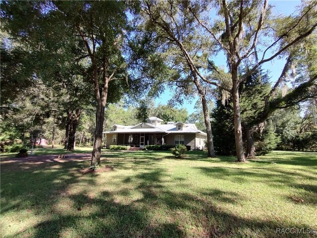 7802 N Fairwind Loop, Hernando, FL 34442 - view of grassy yard with a porch