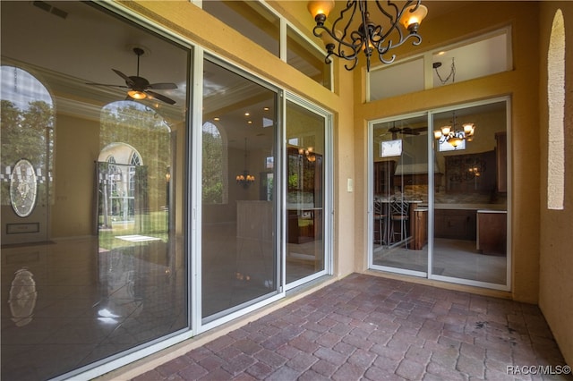 exterior space featuring ceiling fan with notable chandelier