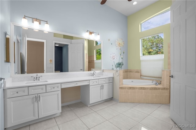 bathroom featuring tile patterned flooring, vanity, ceiling fan, and tiled tub