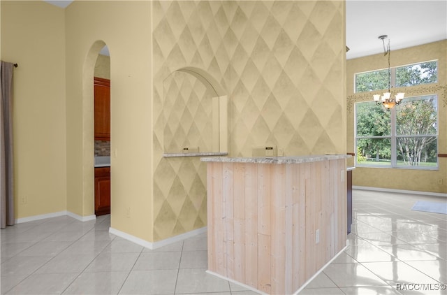 kitchen with light tile patterned flooring, decorative light fixtures, and a notable chandelier