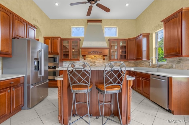 kitchen featuring appliances with stainless steel finishes, a kitchen island, custom range hood, and sink