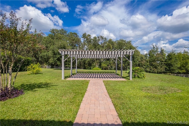 view of property's community with a yard and a pergola