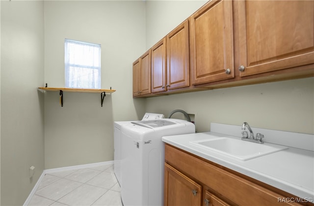 clothes washing area featuring sink, light tile patterned floors, cabinets, and independent washer and dryer