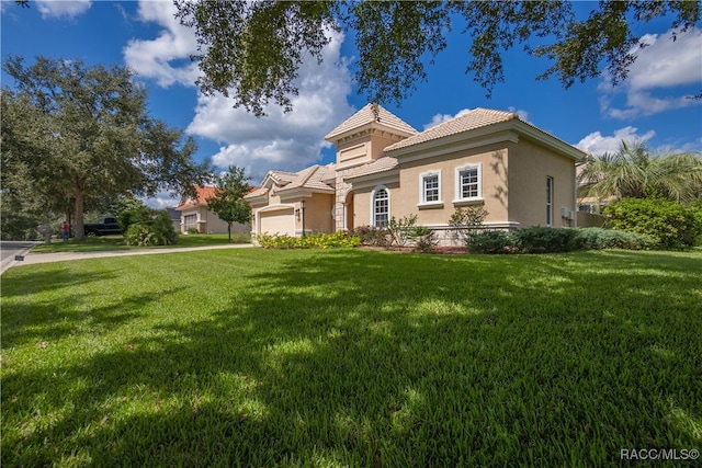 mediterranean / spanish-style home featuring a garage and a front yard