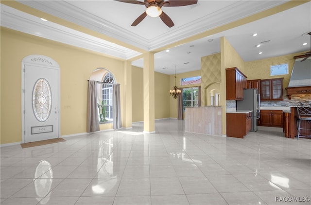 interior space with backsplash, stainless steel refrigerator, light tile patterned floors, and ornamental molding