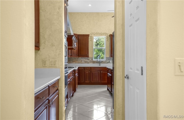 kitchen featuring decorative backsplash, sink, and light tile patterned flooring