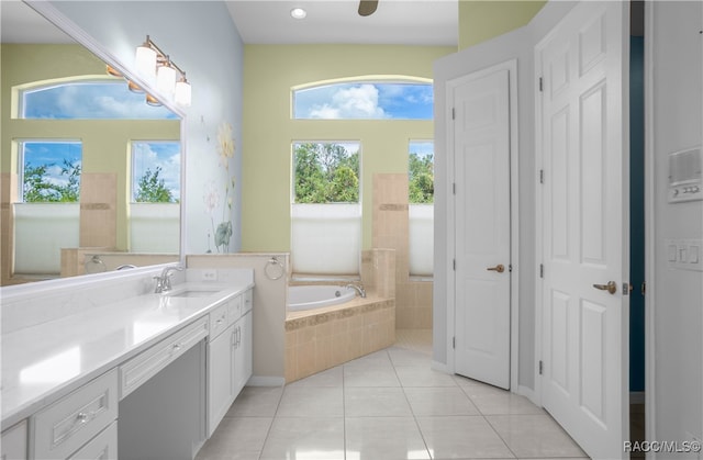 bathroom featuring tile patterned flooring, vanity, and tiled tub