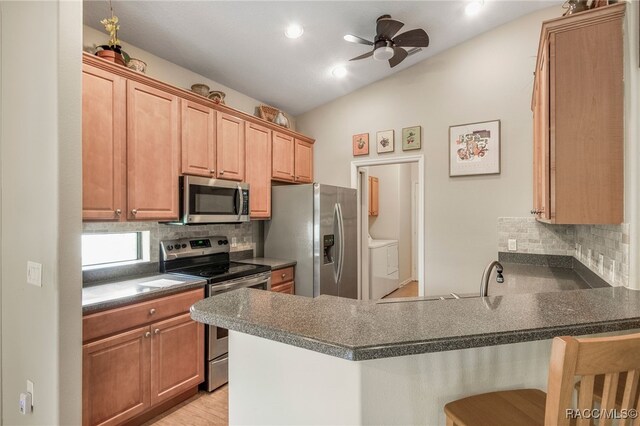 1052 W Diamond Shore Loop, Hernando, FL 34442 - kitchen featuring stainless steel appliances, vaulted ceiling, a peninsula, tasteful backsplash, and dark countertops